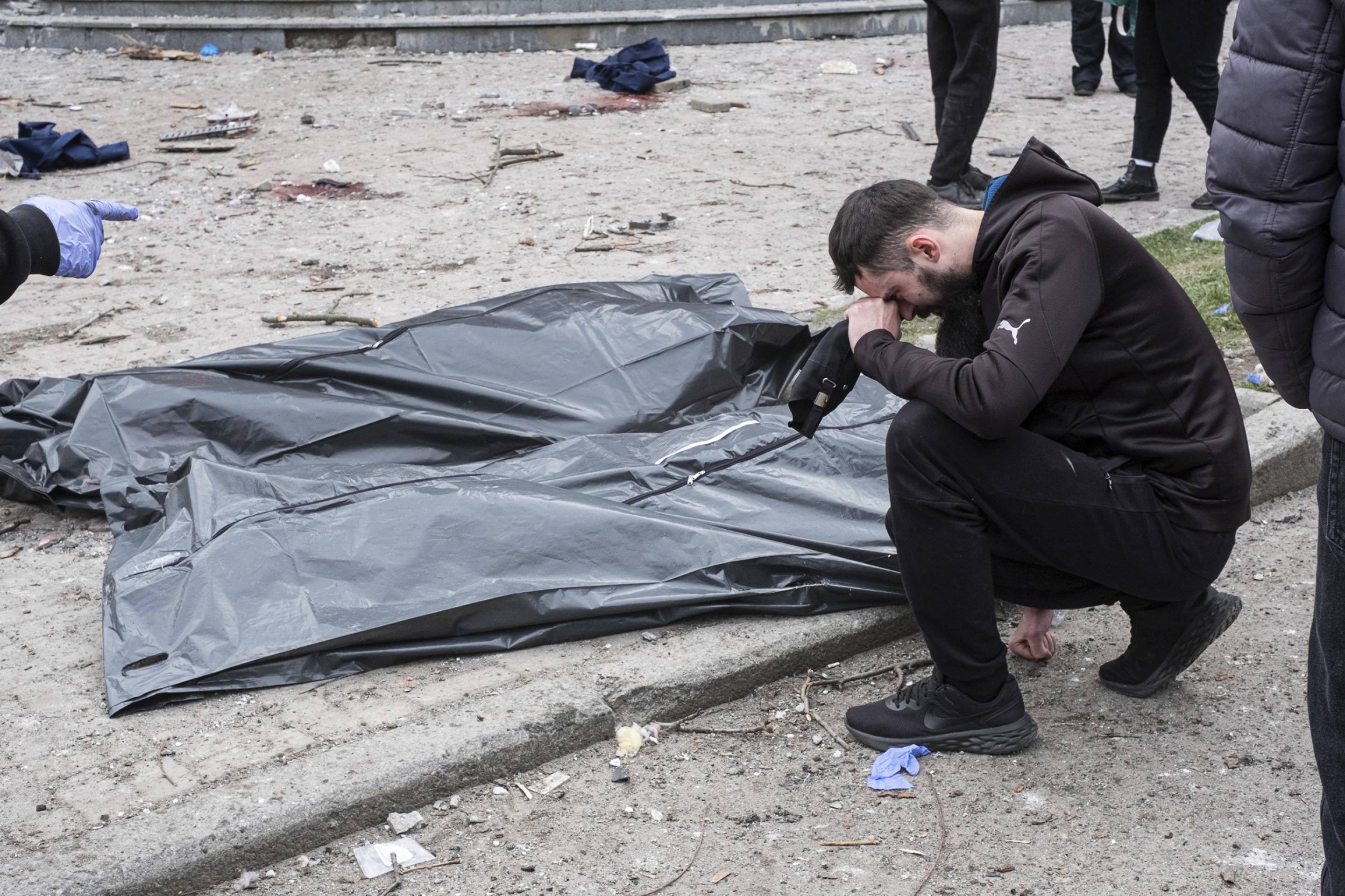 Чоловік плаче біля трупів після російського ракетного удару по Сумах, Україна, неділя, 13 квітня 2025 р.